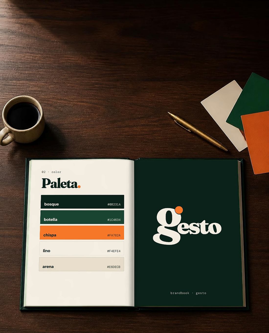 Brandbook de gesto abierto sobre una mesa de madera, junto a un café y muestras de color