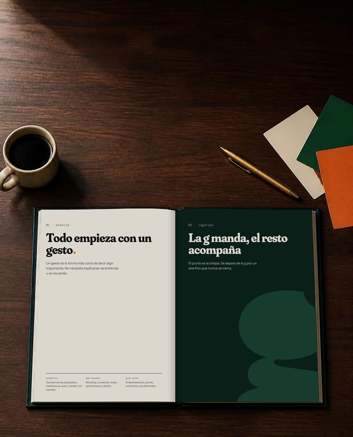Brandbook de gesto abierto sobre una mesa de madera, en las páginas de esencia y logotipo